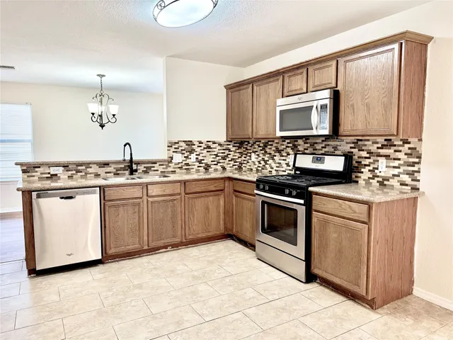 a kitchen with granite countertop a stove and a microwave