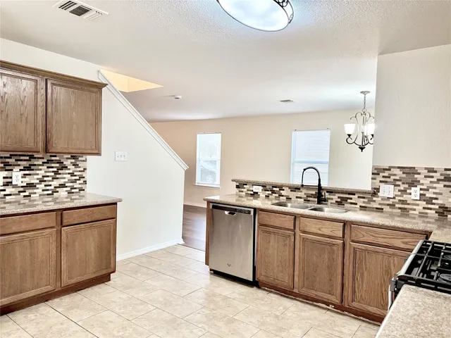 a kitchen with a stove sink and cabinets