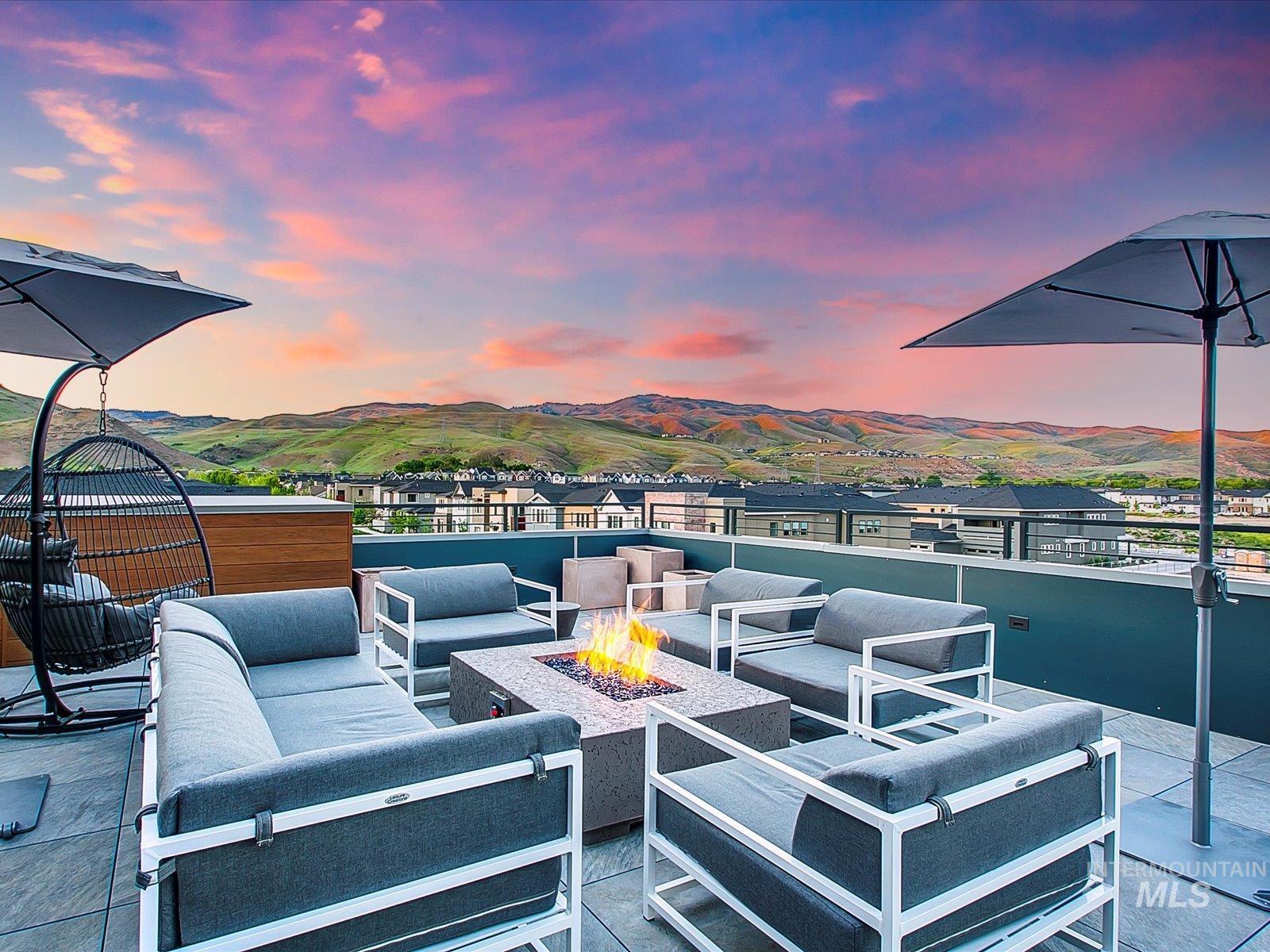 Patio terrace at dusk with an outdoor living space with a fire pit, a patio area, and a mountain view