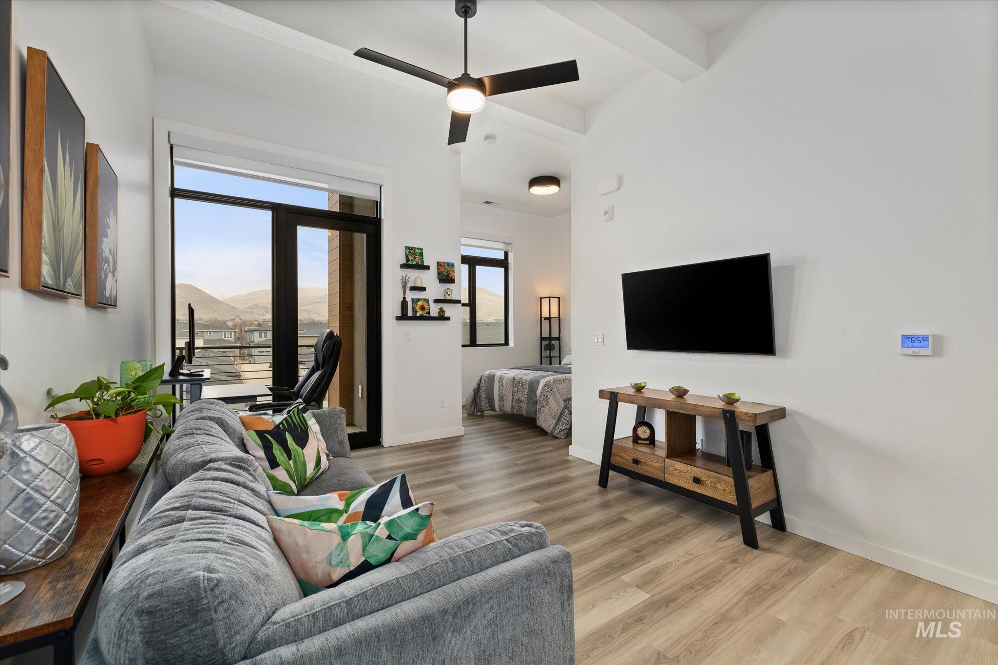 3850 East Haystack Street, Unit 302 Boise, ID 83716 - Photo 12 of 50 Living room featuring light wood finished floors, beamed ceiling, and ceiling fan