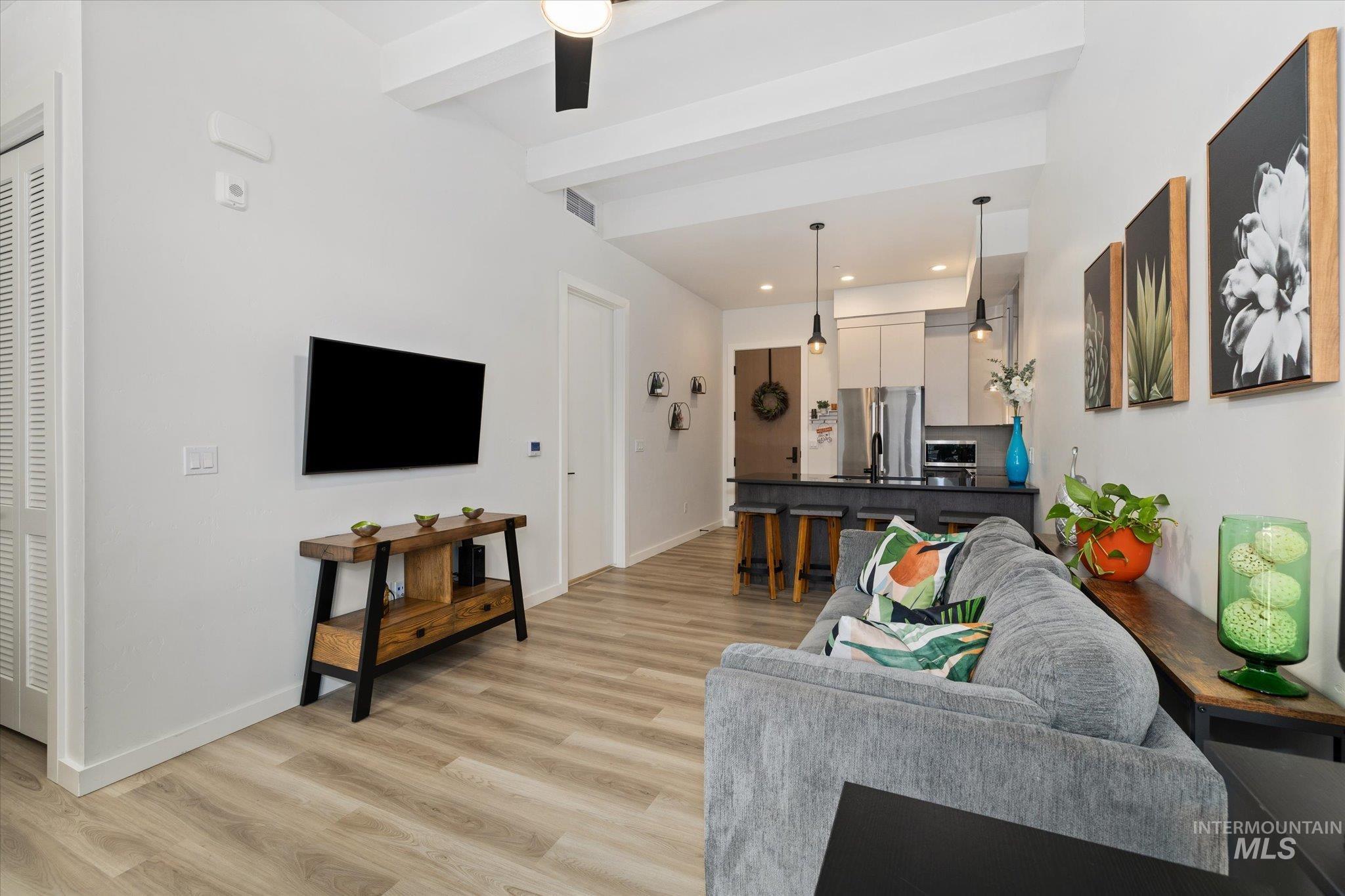 3850 East Haystack Street, Unit 302 Boise, ID 83716 - Photo 15 of 50 Living area featuring beamed ceiling, light wood-style flooring, recessed lighting, and ceiling fan