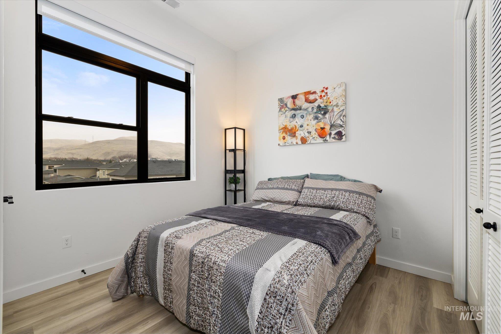 3850 East Haystack Street, Unit 302 Boise, ID 83716 - Photo 16 of 50 Bedroom featuring wood finished floors, a mountain view, and a closet