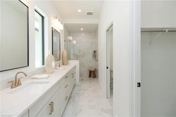 a en suite bathroom with a double vanity sink and a mirror