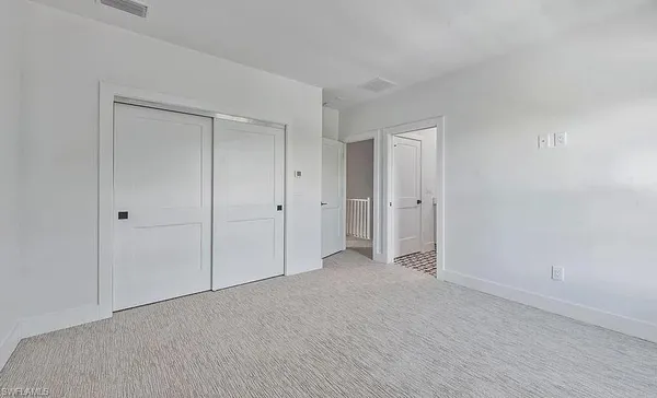an empty room with windows and closet