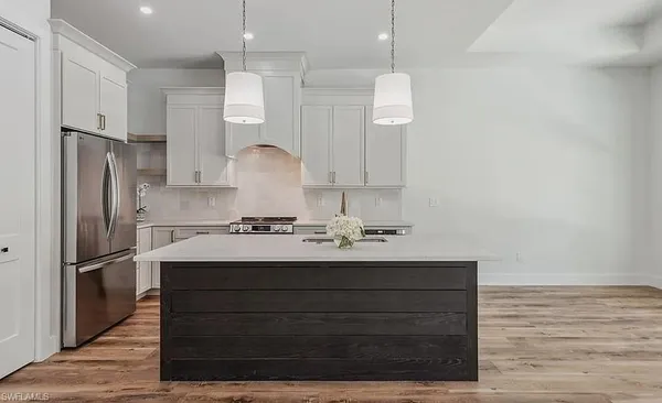 a kitchen with stainless steel appliances granite countertop a sink a stove a refrigerator and a refrigerator