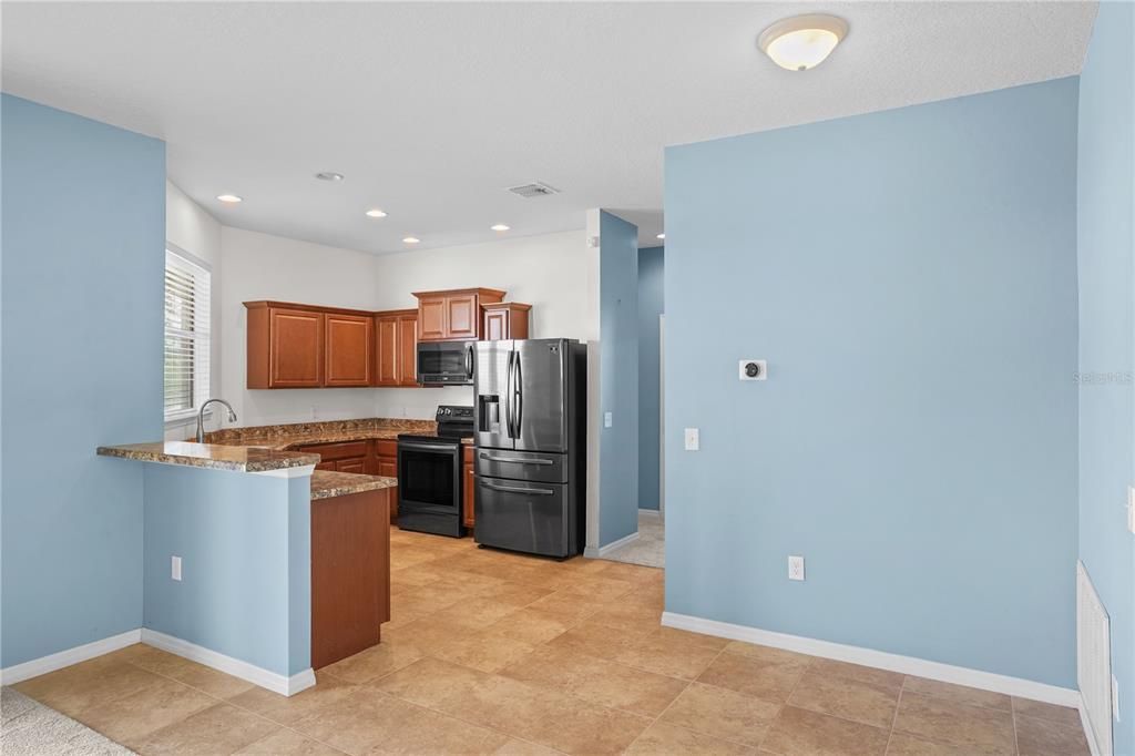 222 Blackstone Creek Road Groveland, FL 34736 - Photo 11 of 49 a kitchen with stainless steel appliances granite countertop a refrigerator and a stove top oven