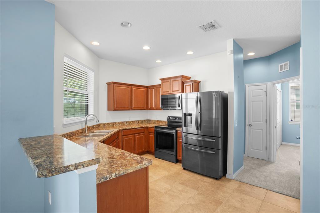 222 Blackstone Creek Road Groveland, FL 34736 - Photo 12 of 49 a kitchen with stainless steel appliances granite countertop a refrigerator sink and stove