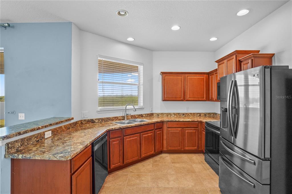 222 Blackstone Creek Road Groveland, FL 34736 - Photo 13 of 49 a kitchen with a sink refrigerator and cabinets