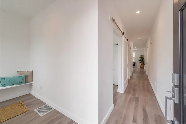 a view of a hallway with wooden floor and staircase