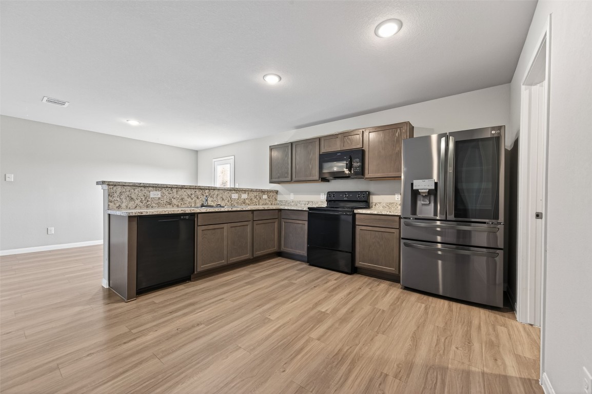 940 21st Street Hempstead, TX 77445 - Photo 12 of 36 a kitchen with stainless steel appliances granite countertop a refrigerator and a stove top oven