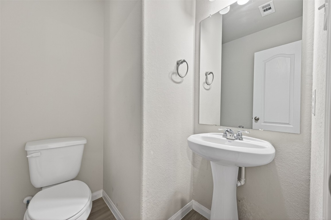 940 21st Street Hempstead, TX 77445 - Photo 17 of 36 a bathroom with a toilet sink and mirror