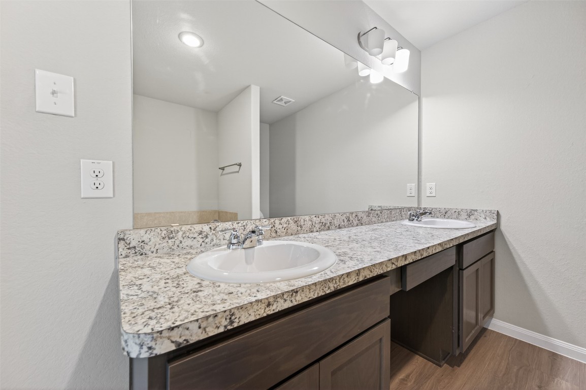 940 21st Street Hempstead, TX 77445 - Photo 31 of 36 a bathroom with a granite countertop sink a large mirror and vanity