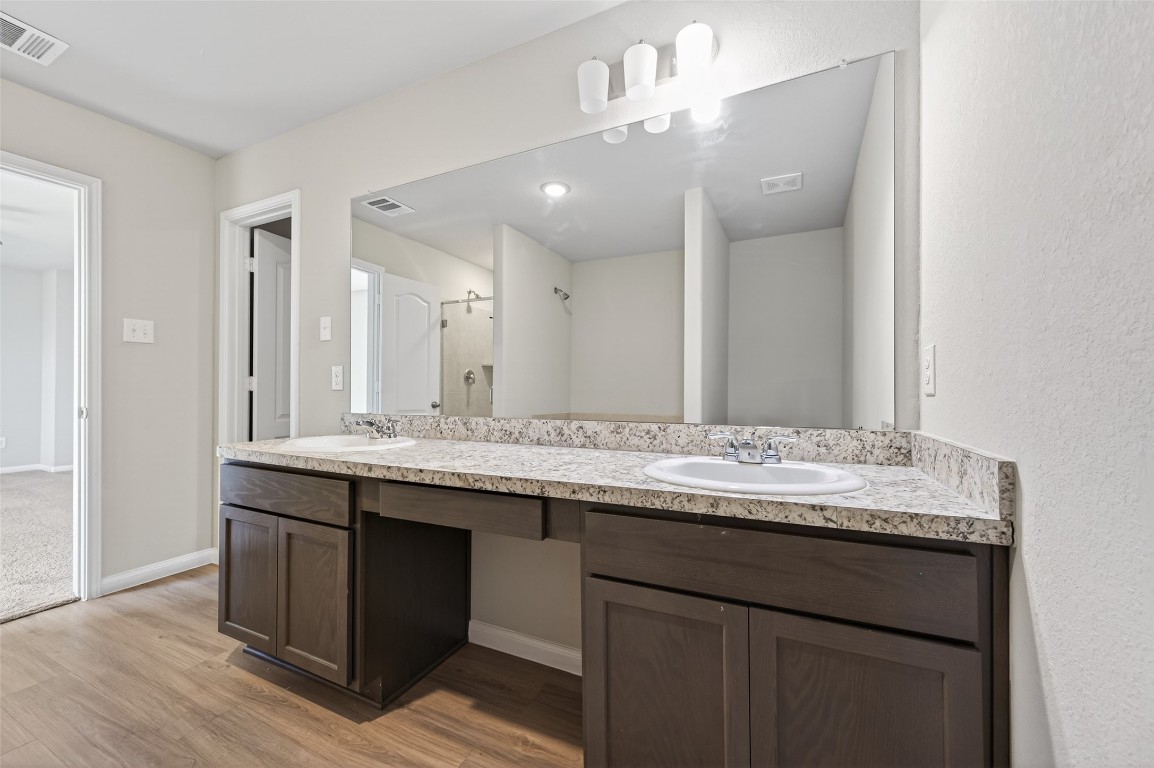 940 21st Street Hempstead, TX 77445 - Photo 34 of 36 a bathroom with a granite countertop sink a large mirror and shower