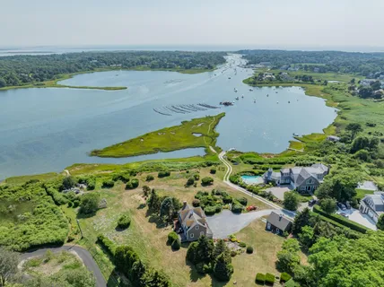 an aerial view of a residential houses with outdoor space and lake view