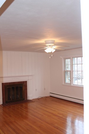 280 Forest Hills Road Springfield, MA 01128 - Photo 10 of 23 an empty room with wooden floor fireplace and windows