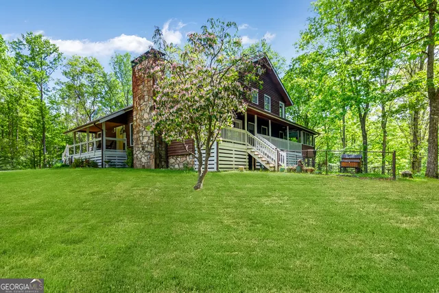 a front view of a house with a yard and trees