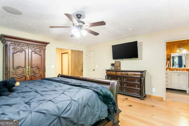 a bedroom with a bed and a flat tv screen on the dresser