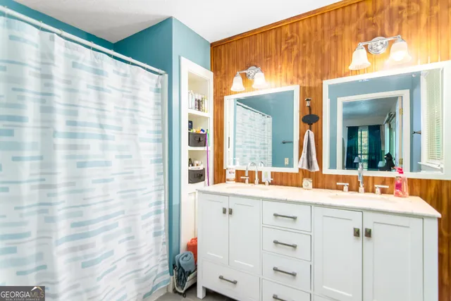 a bedroom with a bed television on desk and a window