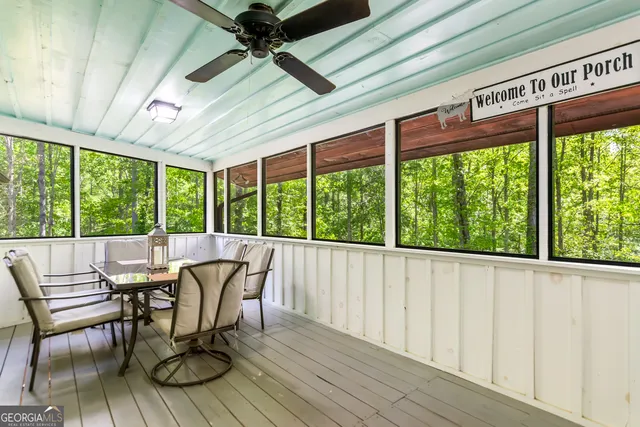 a bedroom with a bed television on desk and a window
