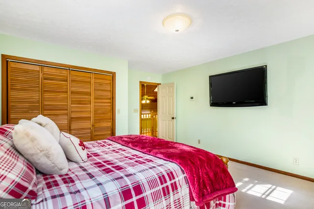 a bedroom with a large bed and a flat screen tv