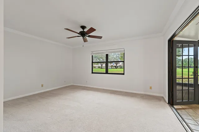 an empty room with a window and a fan