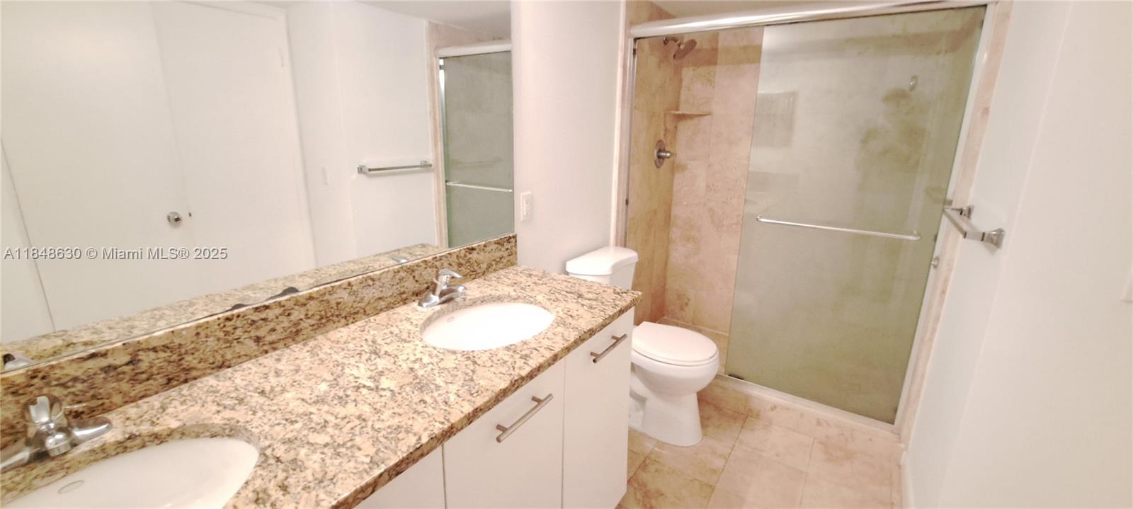 3300 Northeast 191st Street, Unit 1207 Aventura, FL 33180 - Photo 13 of 33 a bathroom with a granite countertop sink toilet and shower