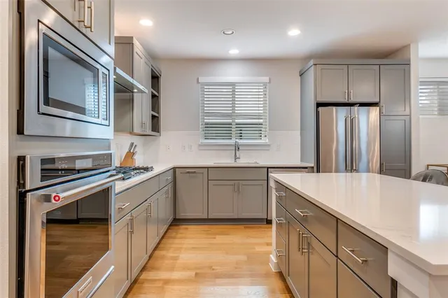 a kitchen with stainless steel appliances granite countertop a sink stove and refrigerator