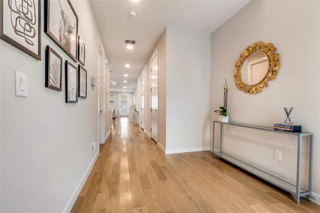 a view of a hallway with wooden floor and staircase