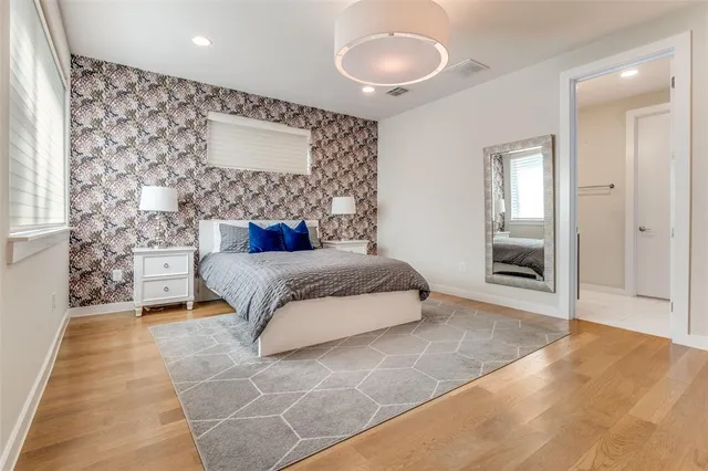a spacious bedroom with a bed and a painting on the wall