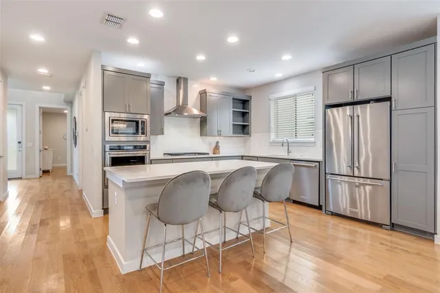 a kitchen with stainless steel appliances granite countertop a refrigerator and a stove top oven
