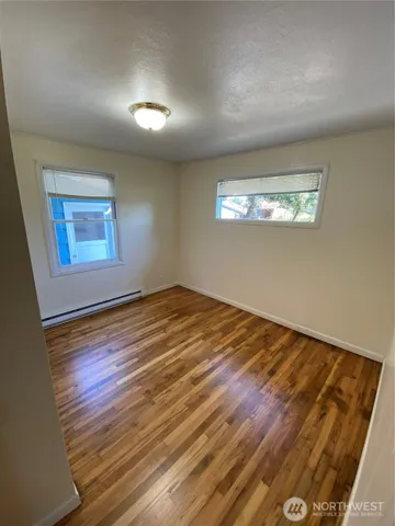 a view of empty room with wooden floor