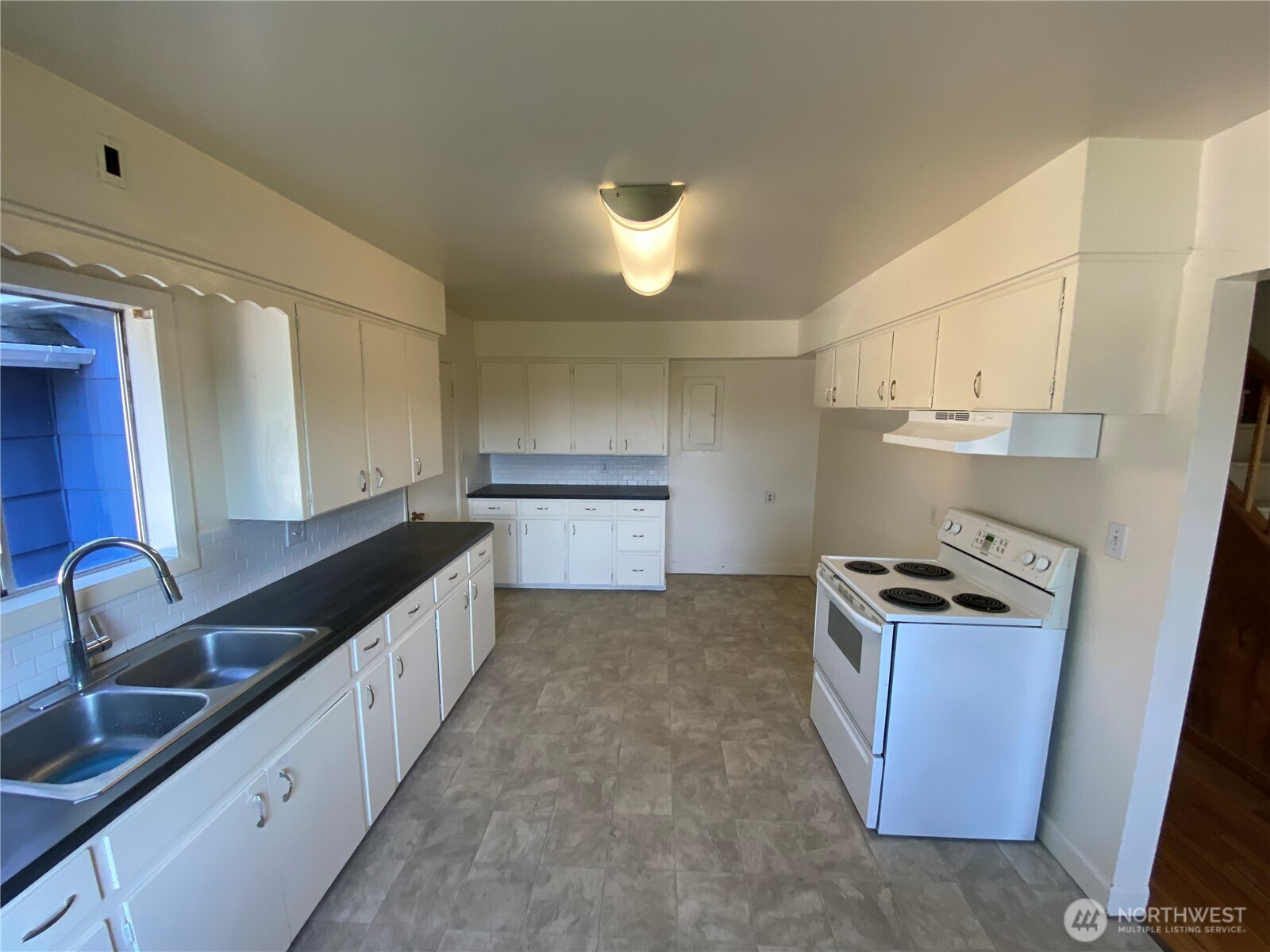 2312 38th Avenue Longview, WA 98632 - Photo 5 of 36 a kitchen with granite countertop a sink and a stove top oven