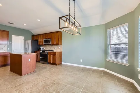 a open kitchen with stainless steel appliances granite countertop a stove a sink dishwasher and a refrigerator with a granite countertops