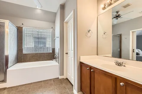 a bathroom with a bathtub shower and a sink