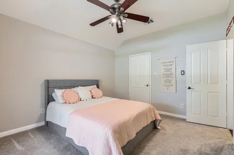 a bedroom with a large bed and a chandelier