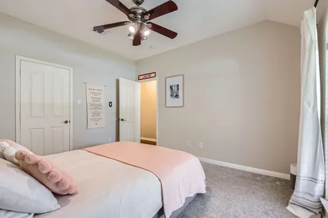 a bedroom with a large bed and a chandelier