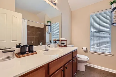 a bathroom with a sink toilet double vanity and mirror