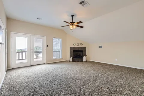 an empty room with windows and a ceiling fan