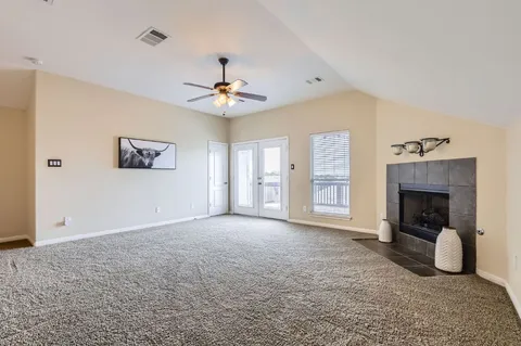 a view of an empty room with window and fireplace