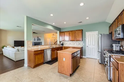 a large kitchen with stainless steel appliances granite countertop a stove and a sink