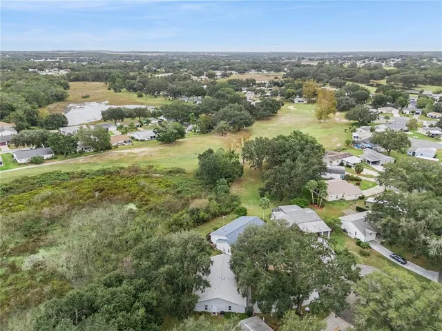an aerial view of residential houses with outdoor space and trees