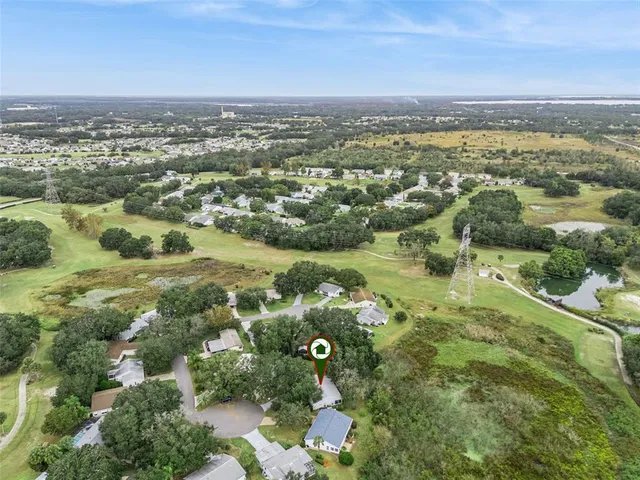 an aerial view of residential houses with outdoor space and trees