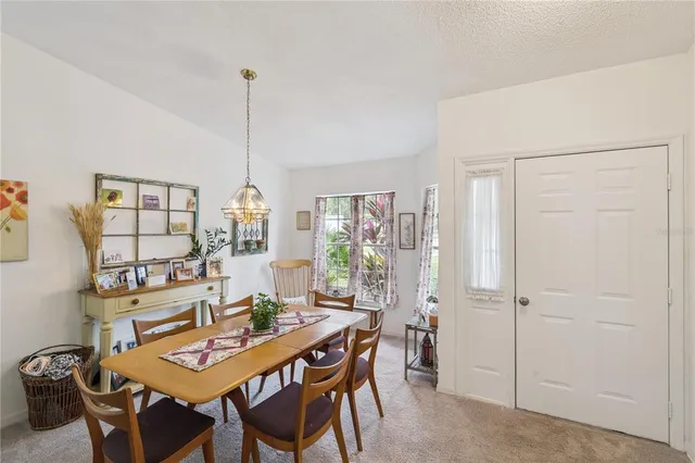 a dining room with furniture a chandelier and wooden floor