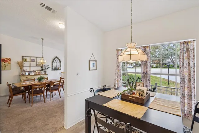 a view of a dining room and livingroom with furniture wooden floor a chandelier