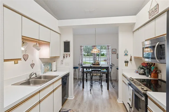 a kitchen with kitchen island granite countertop a sink appliances cabinets and furniture