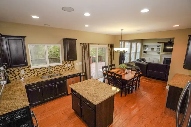 a dining room with furniture wooden floor a rug and a chandelier