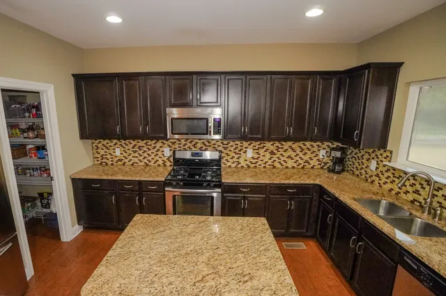 a bathroom with a granite countertop sink and a bathtub