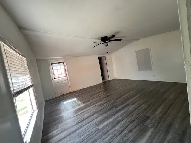 a view of empty room with window and wooden floor