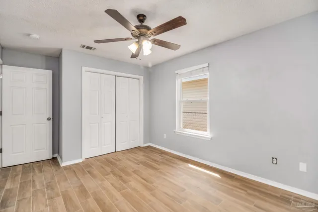 a view of a big room with wooden floor and windows in a room