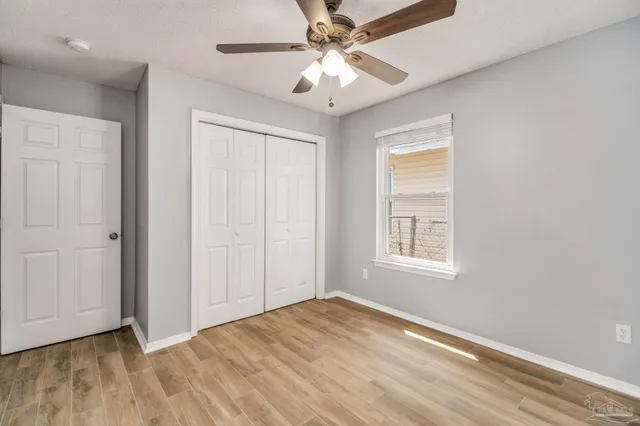 an empty room with fan and windows